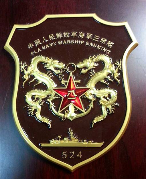 053H3型导弹护卫舰三明舰的舰徽。这个舰徽设计比较具有中国传统文化，双龙将海军军徽守卫在中央，下面是军舰的侧影。整个外形设计也符合该舰的时代特征。