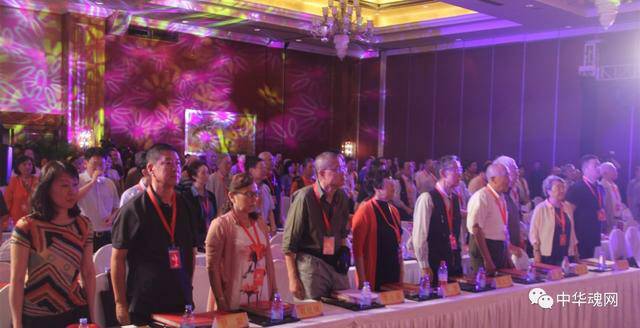 会场上的领导嘉宾起立奏唱《中华人民共和国国歌》。 