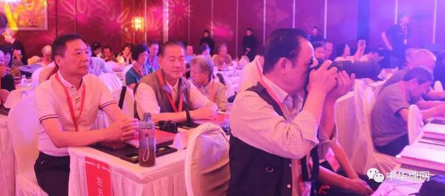 在聆听报告的同时，不忘抓拍精彩的瞬间。 