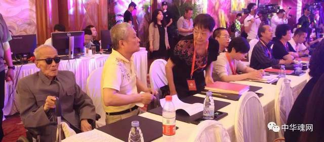 全国唯一健在的中央特科老战士姚子建（左）因为坐轮椅不方便登上主席台，就一直在会场最后一排专心听大家的讲话。 