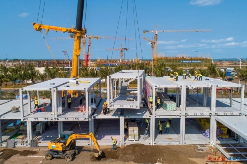 海口江东新区1.5级企业港项目现场，工人们有序吊装装配式箱体模块